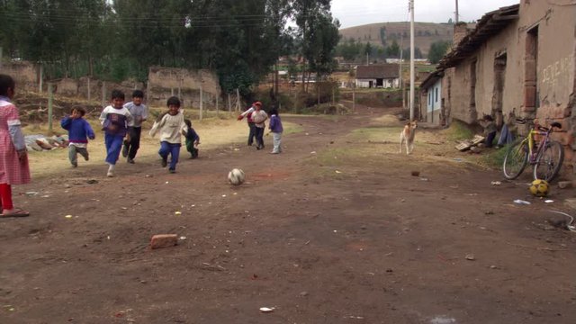 Children playing informal soccer in an Ecuadorean alley