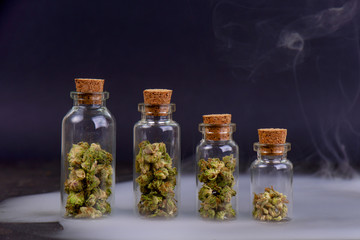Detail of assorted jars with cannabis calyxes (sour tangie strain) isolated on black