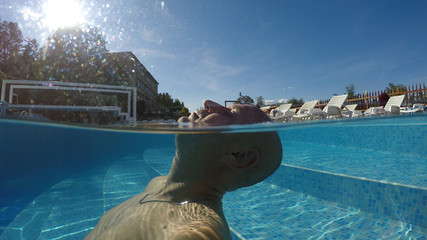 A man resting in a spa pool with thermal water, half underwater shot