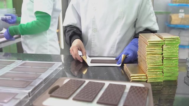 Packaging chocolate bars in wrappers in factory