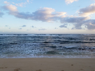 Fototapeta na wymiar Waves of the ocean waters move towards the beach of Camp Mokuleia Beach