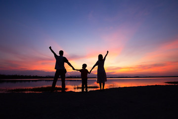 Fototapeta premium The shadow of the family, parents, children, lakeside evening.