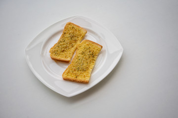 Home made Herb and Garlic Bread on white ceramic plate isolated on white background.