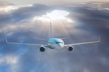 Fototapeta premium White passenger airplane in the clouds. travel by air transport