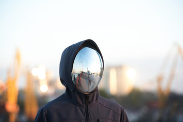 Faceless character with the mirror mask with port in background.