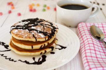 Breakfast. Pancakes on a plate. Sprinkled with powdered sugar.