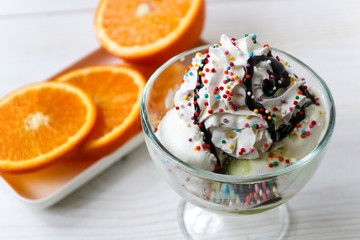 Close-up shot of vanilla ice-cream garnished with whipped cream and sprinkled served on table. 
