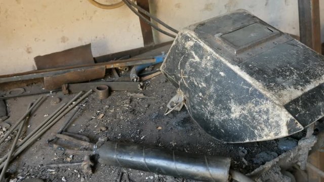 The panoramic view of welding mask and tools used by the welder on workbench. Manufacturing, workshop
