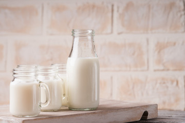 Jars and bottle with milk on a cutting board 