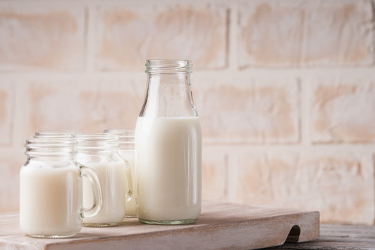 Jars and bottle with milk on a cutting board 