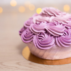 Obraz na płótnie Canvas birthday or anniversary concept - purple cake over wooden background