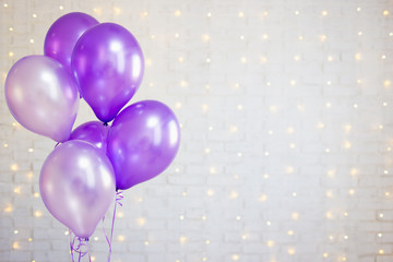 party concept - air balloons over white brick wall background with lights