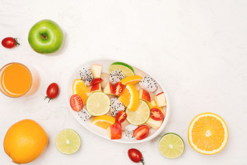 Fruity summer salad in white bowl on white background
