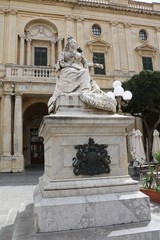 Fototapeta na wymiar Statue of Queen Victoria in front of the Bibliotheca at Republic Square in Valletta, Malta 