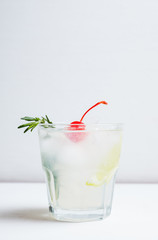 Bitter old-fashioned cocktail with lemon slice and cherry. Selective focus.