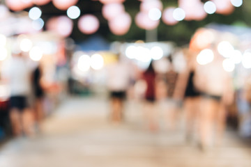 Blurred background of people are walking in walking street night market for shopping and dining local food, souvenir and travel at night.