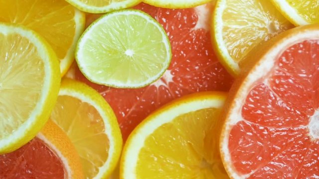 Slow motion footage of camera panning over fresh slices of citrus fruits