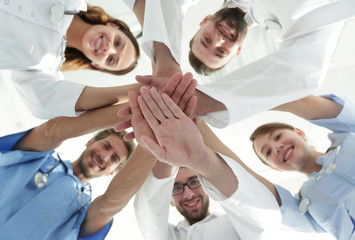 Fototapeta na wymiar bottom view.a team of doctors at the medical center clasped their hands together