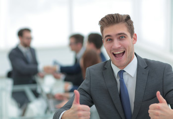 Portrait of happy energetic businessman with thumbs up while  co