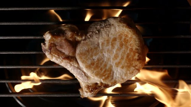 TOP VIEW: Pork steak is grilled in a flame - SLOW MOTION