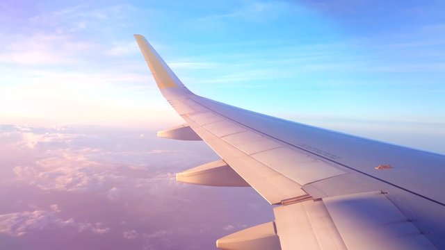 Airplane flight. Wing of an airplane flying above the clouds. View from the window of the plane. Aircraft. Traveling. 4K UHD video footage. 3840X2160