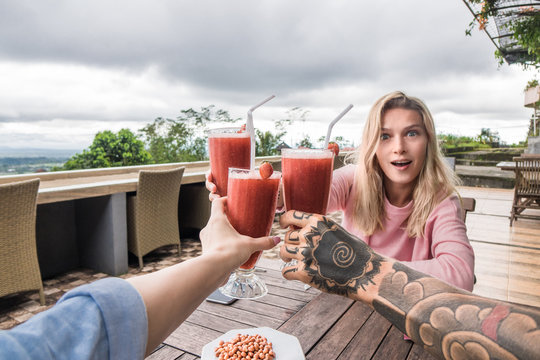 partial view of friends clinking glasses at table during vacation in bali, indonesia