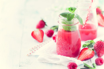 Healthy antioxidant red smoothie with apple juice, fresh strawberries, raspberries and mint. With copy space for your text, recipe or greeting