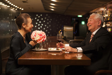 レストランで食事をする老夫婦。