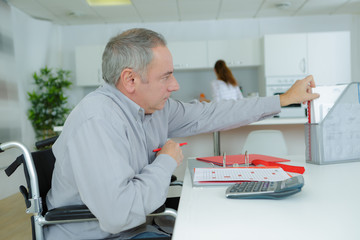 handicapped accountant reaching for a file