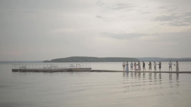 Company people standing pier summer evening