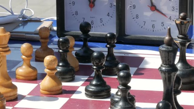 April 21, 2018 - Kamenskoye, Ukraine: Children play chess in street. Street Chess Tournament outdoor, chess clock presses the hand