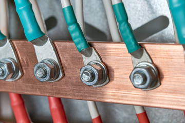 Electric bus bars connected to it by wires or cables. The cables are connected with cable lugs and nuts bolts. Accumulation and interlacing of wires or cables in the electrical Cabinet.