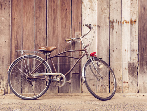 cyclists outdoor lifestyle. Classic vintage retro bicycle against the wooden old crack wall at home in Asia countryside. Old bike vintage style background