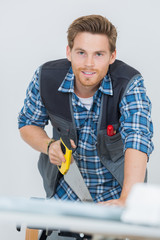portrait of carpenter working with a saw at construction site