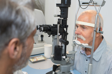 Fototapeta na wymiar senior man checking his vision with ophtalmologist