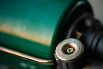 Background image of green auto part close-up. Green metallic surface and gold circle.