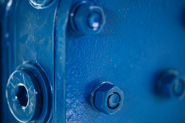 Blue metal rough surface of part with bolts and nuts. Blue painted of auto part. Automotive grunge background image.