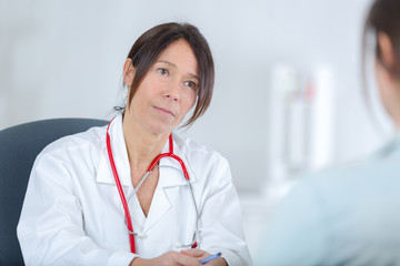 female doctor listening to her patientin office
