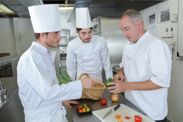 professional chef and assistans prepare dish at restaurant