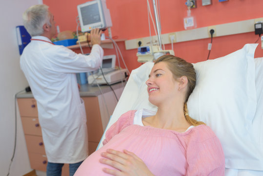 doctor doing ultrasound on belly of pregnant woman in clinic
