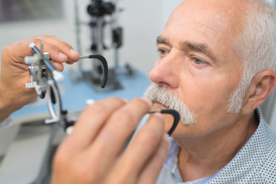 senior man having sight test at optometrist