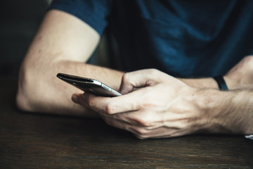 Close up of a man using mobile smart phone view from back