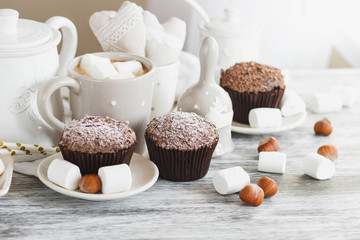 Cups with cacao and marshmallow, cupcakes and different decorations