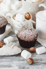 Cups with cacao and marshmallow, cupcakes and different decorations