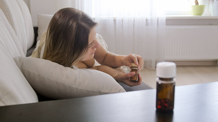 Obraz na płótnie Canvas Closeup photo of bottle with pills on bedside table