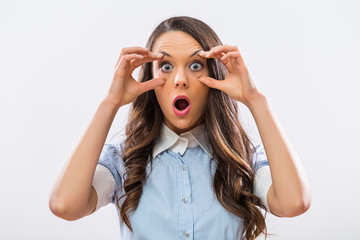 Image of businesswoman with big blue eyes staring on gray background.