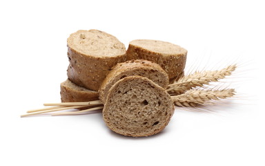 Loaf of integral bread with sesame, ears of wheat and slices isolated on white background