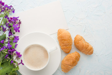 Coffee with flowers and croissants top view, with empty space for labeling or advertising