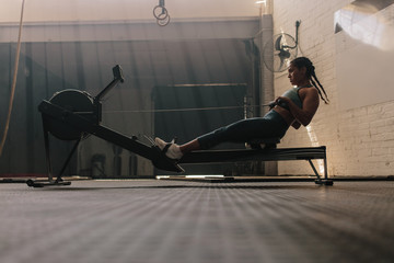 Female using rowing machine at health club