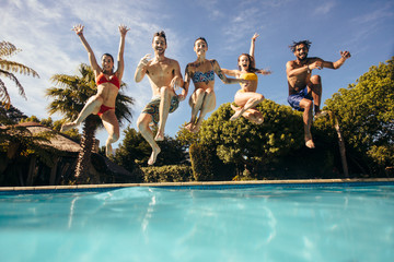 Crazy young people jumping into a pool